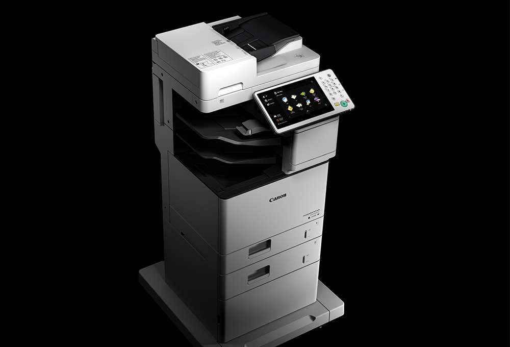 Canon office multi-function printer with touchscreen and a black background.